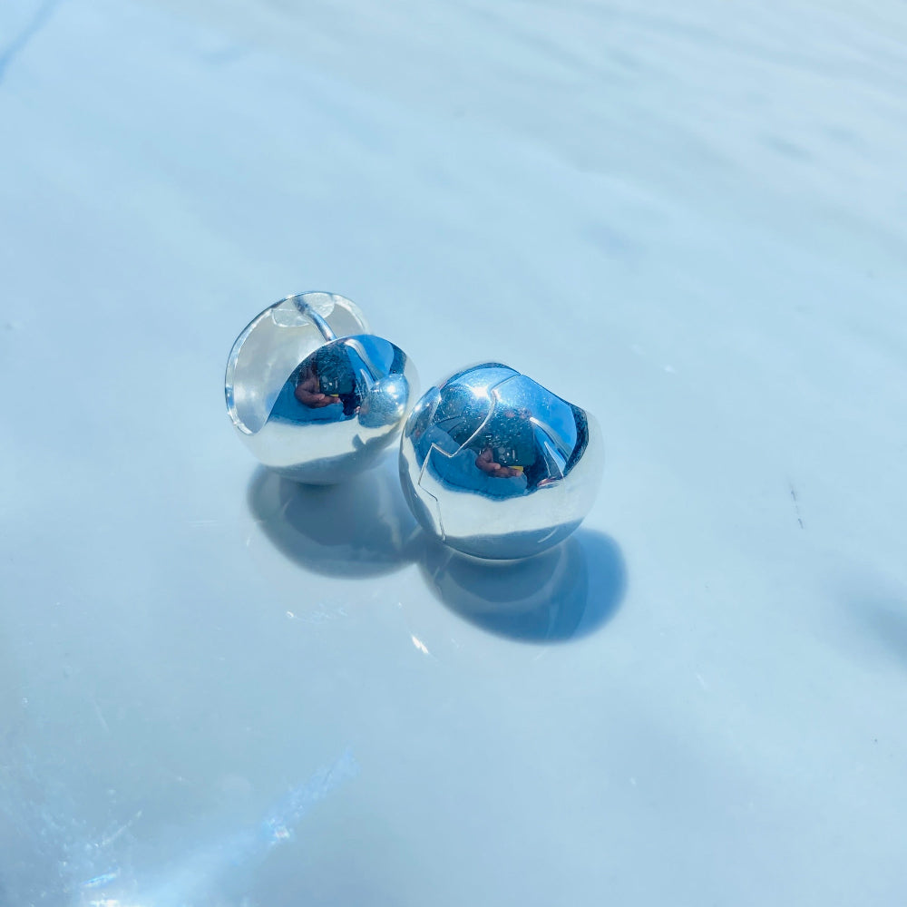 Pair of clear earrings with blue gemstones on a light gray surface. Silver earrings on a white surface with a blurred background silver dome earrings women ladies queens 925 silver sterling silver craftsmanship exclusive Deep Shine Jewellers jewellery jewelry Your Time To Shine elegant shop now trending