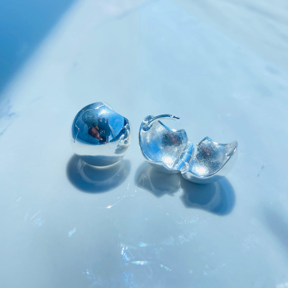 Clear glass earrings on a reflective surface Silver earrings on a white surface with a blurred background silver dome earrings women ladies queens 925 silver sterling silver craftsmanship exclusive Deep Shine Jewellers jewellery jewelry Your Time To Shine elegant shop now trending