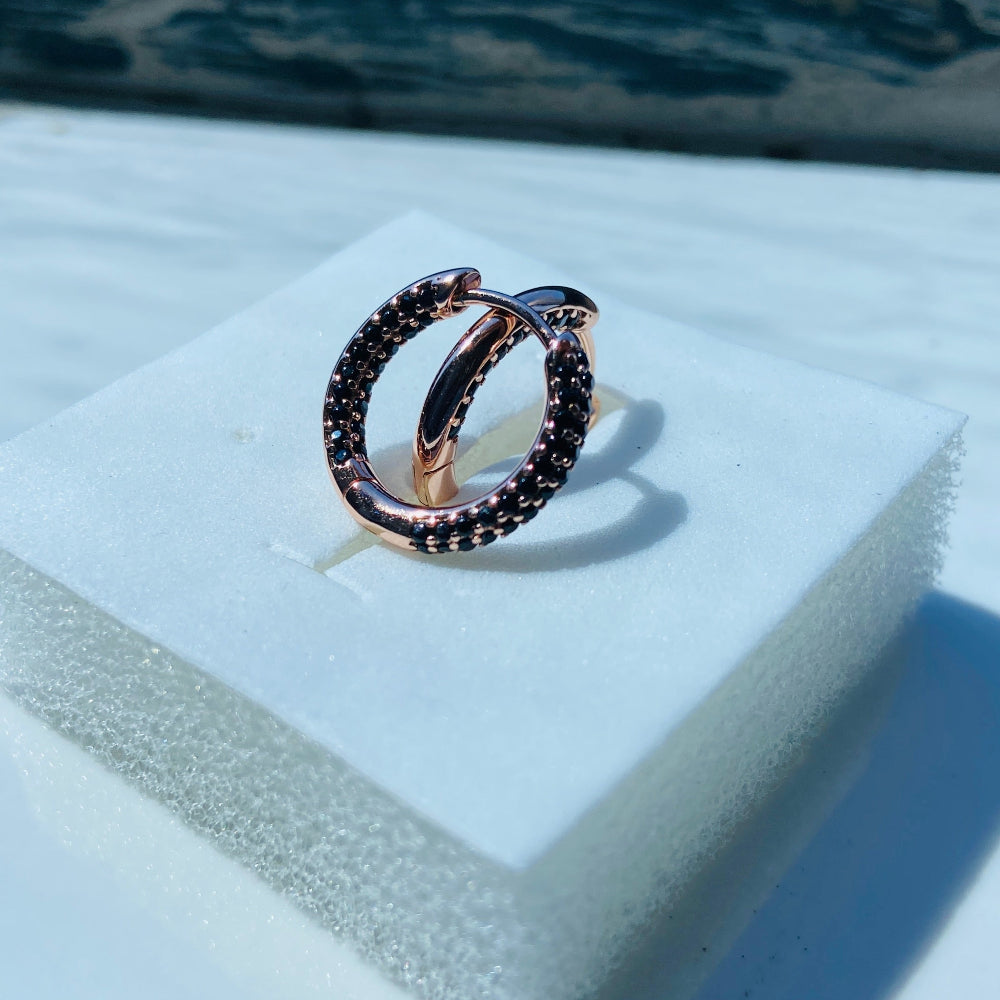 Rose gold ring with black gemstones on a white stand Rose gold ring with black gemstones on a white box against a blue window background rose gold flooded sleeper hoop earrings for women ladies queens black stones black diamond cubic zirconia lab diamond 925 silver sterling silver exclusive Deep Shine Jewellers jewellery jewelry Your Time To Shine DSJ