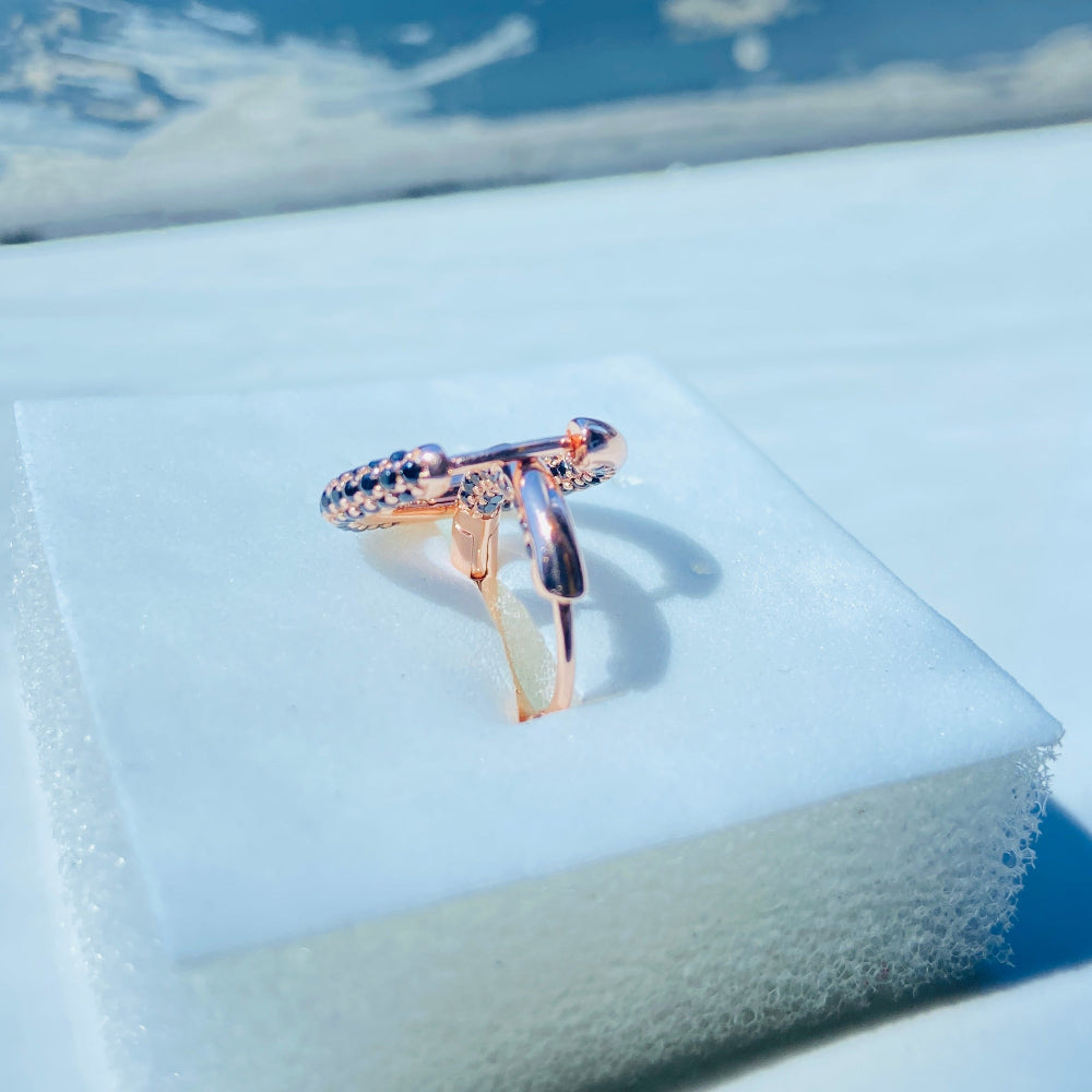 Rose gold ring with black gemstones on a white box against a blue window background rose gold flooded sleeper hoop earrings for women ladies queens black stones black diamond cubic zirconia lab diamond 925 silver sterling silver exclusive Deep Shine Jewellers jewellery jewelry Your Time To Shine DSJ