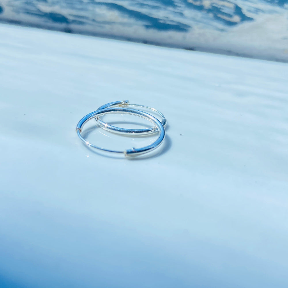 Silver ring on a blue fabric background Two silver rings on a light blue fabric surface silver sleeper hoop earrings for king queen womens mens 925 silver sterling silver exclusive Deep Shine Jewellers jewellery jewelry Your Time To Shine shop now DSJ affordable luxury high quality
