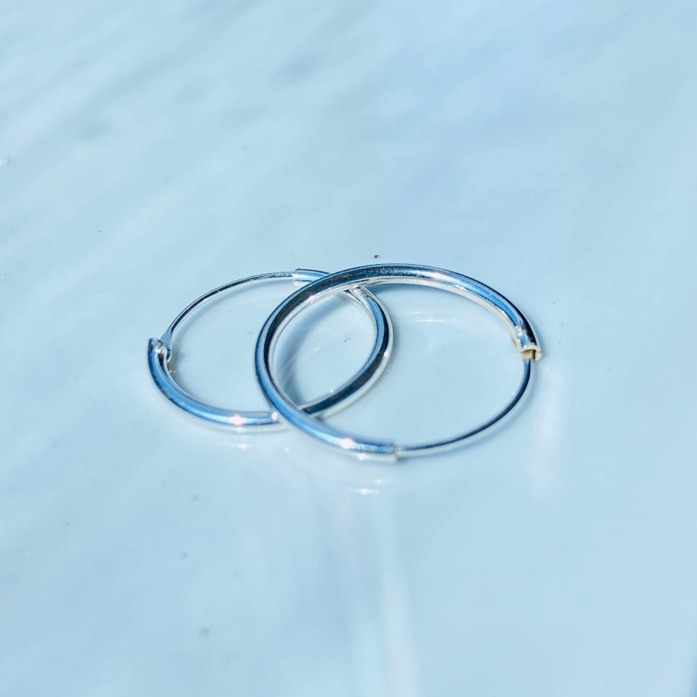 Two silver rings on a light blue fabric surface silver sleeper hoop earrings for king queen womens mens 925 silver sterling silver exclusive Deep Shine Jewellers jewellery jewelry Your Time To Shine shop now DSJ affordable luxury high quality