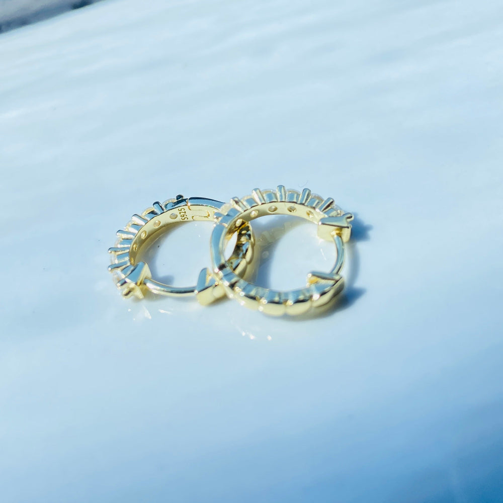 Gold hoop earrings on a light blue surface Gold ring with diamonds on a white box Gold silver ice sleeper hoop earring yellow gold 925 silver sterling silver womens ladies queens shine bright exclusive Deep Shine Jewellers jewellery jewelry DSJ Your Time To Shine affordable luxury trendy best beauty diamonds cubic zirconia