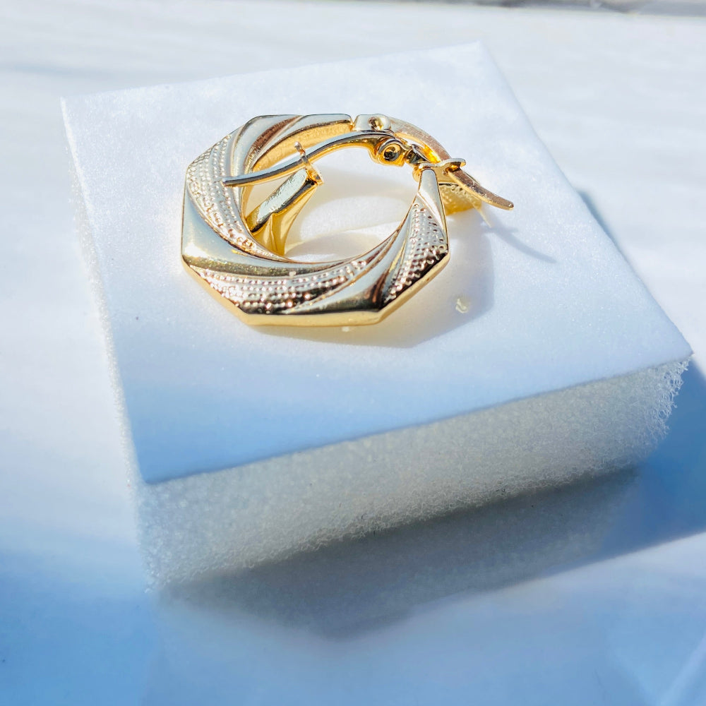 Gold ring with a central stone on a white cushioned stand against a blue background. Gold Detailed Octagon Earrings jewellery jewelry stainless steel gold plated earrings queens ladies womens Deep Shine Jewellers Your Time To Shine Affordable luxury DSJ