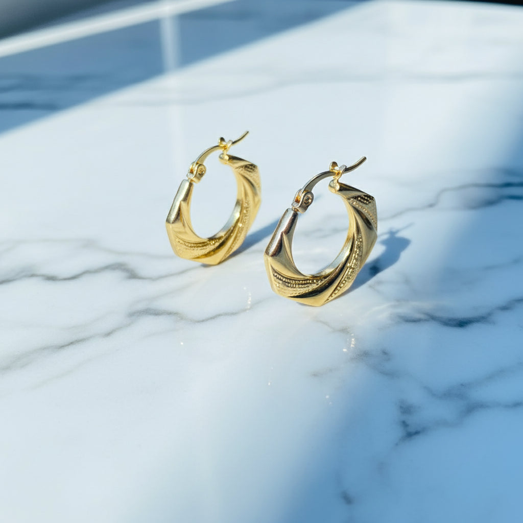 Gold hoop earrings on a white stand with a blurred background Gold Detailed Octagon Earrings jewellery jewelry stainless steel gold plated earrings queens ladies womens Deep Shine Jewellers Your Time To Shine Affordable luxury DSJ