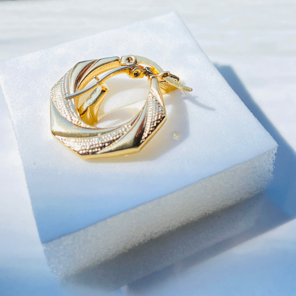 Gold ring with interlocking design on a light blue jewelry box. Gold Detailed Octagon Earrings jewellery jewelry stainless steel gold plated earrings queens ladies womens Deep Shine Jewellers Your Time To Shine Affordable luxury DSJ