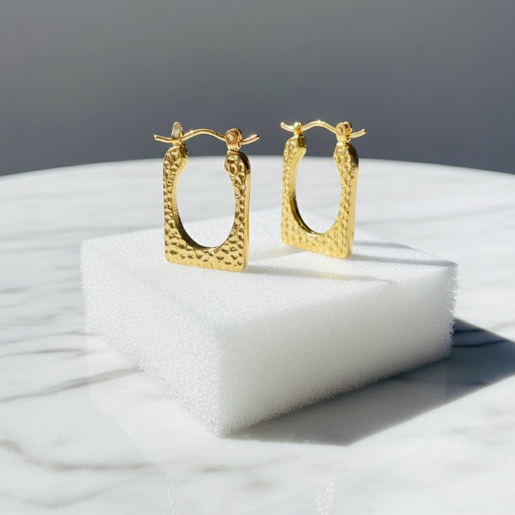 Gold ring with pearls on a white stand against a blue background Gold hoop earrings on a light blue surface gold detailed rectangle earrings exclusive by Deep Shine Jewellers jewellery jewelry DSJ Your Time To Shine golden shine