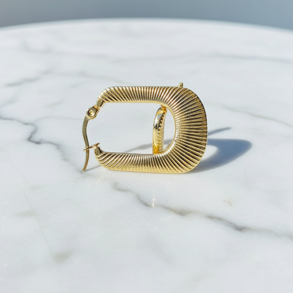 Gold hoop earring on a car window with a blue sky background Gold striped rectangle earrings jewellery jewelry Deep Shine Jewellers stainless steel gold-plated affordable luxury DSJ Your Time To Shine exclusive radiant womens lady's queens kingdom