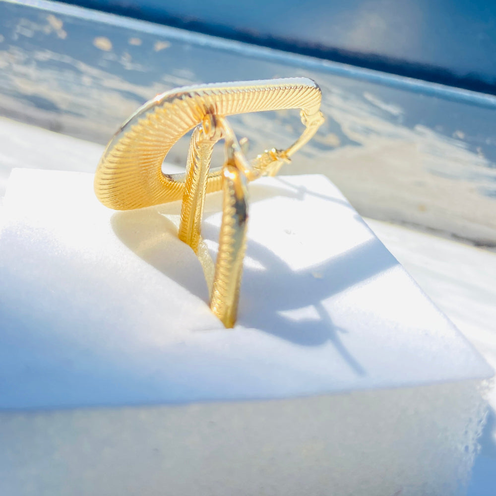 Gold ring on a white surface with a blue background