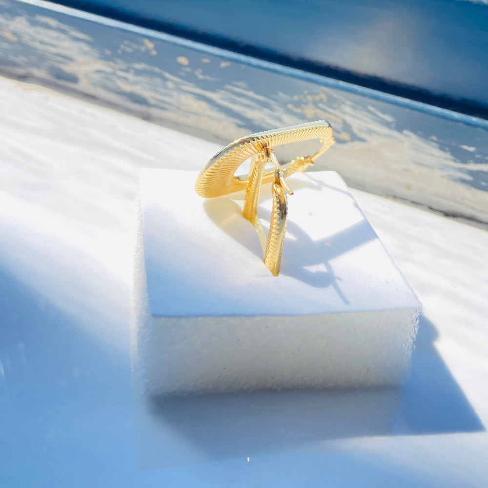 Gold ring on a white box with a blurred outdoor background Gold striped rectangle earrings jewellery jewelry Deep Shine Jewellers stainless steel gold-plated affordable luxury DSJ Your Time To Shine exclusive radiant womens lady's queens kingdom