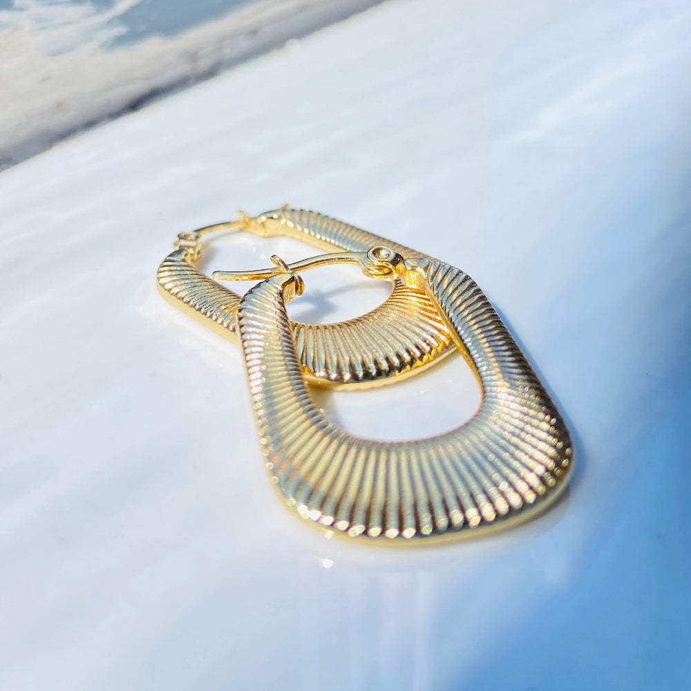 Gold hoop earrings on a white surface with a blue background Gold striped rectangle earrings jewellery jewelry Deep Shine Jewellers stainless steel gold-plated affordable luxury DSJ Your Time To Shine exclusive radiant womens lady's queens kingdom