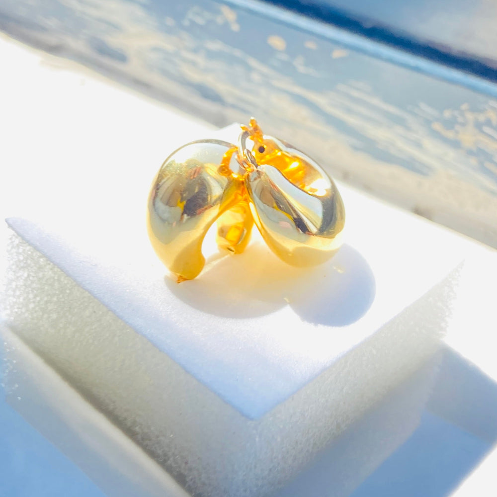 Gold earrings on a white stand with a blurred outdoor background gold silver bubble dome hoop earrings for women ladies queens exclusive craftsmanship gold 925 silver sterling silver gold-plated jewellery jewelry Deep Shine Jewellers DSJ Your Time To Shine affordable luxury beauty trendy shop now 