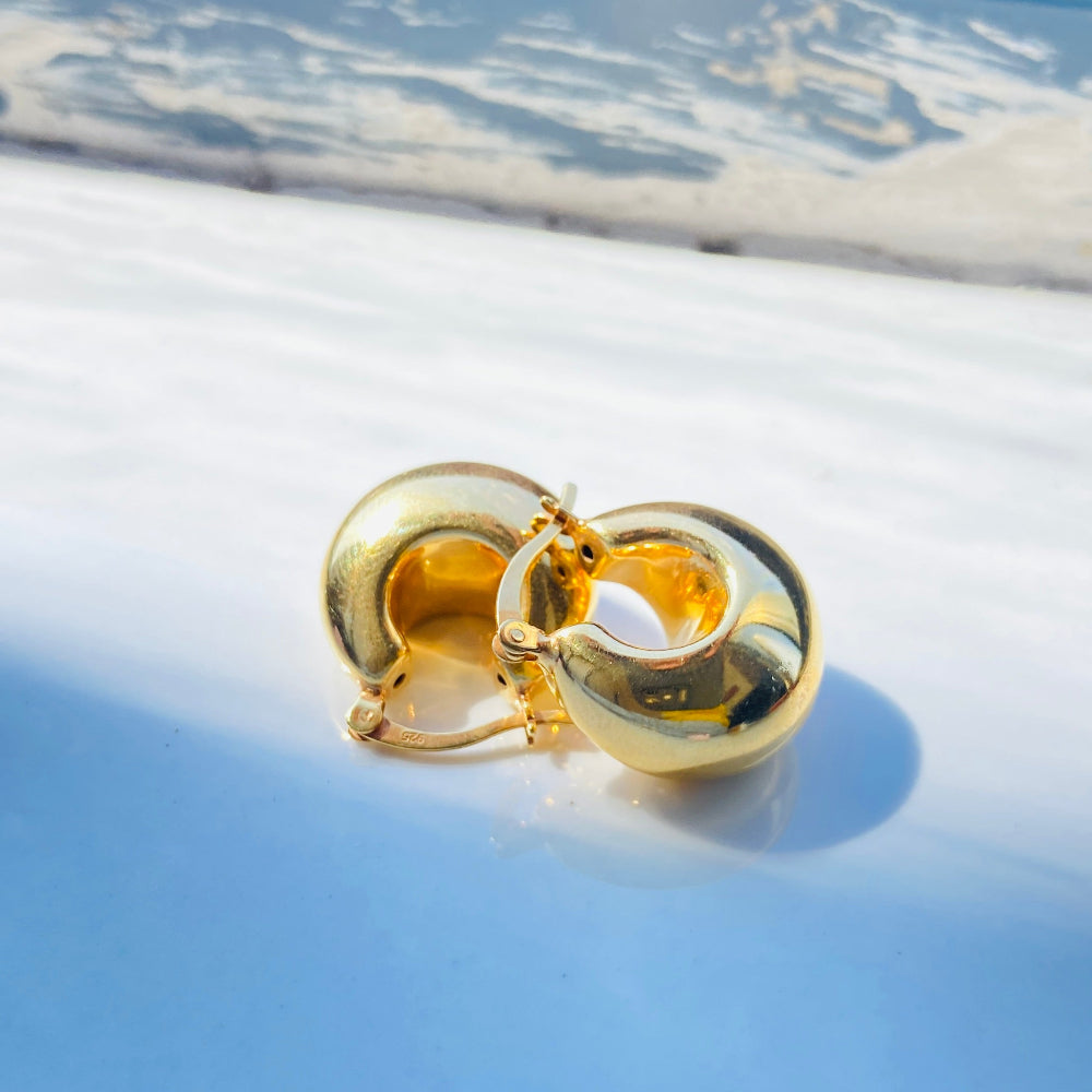 Gold hoop earrings on a light blue surface with a blurred background gold silver bubble dome hoop earrings for women ladies queens exclusive craftsmanship gold 925 silver sterling silver gold-plated jewellery jewelry Deep Shine Jewellers DSJ Your Time To Shine affordable luxury beauty trendy shop now 