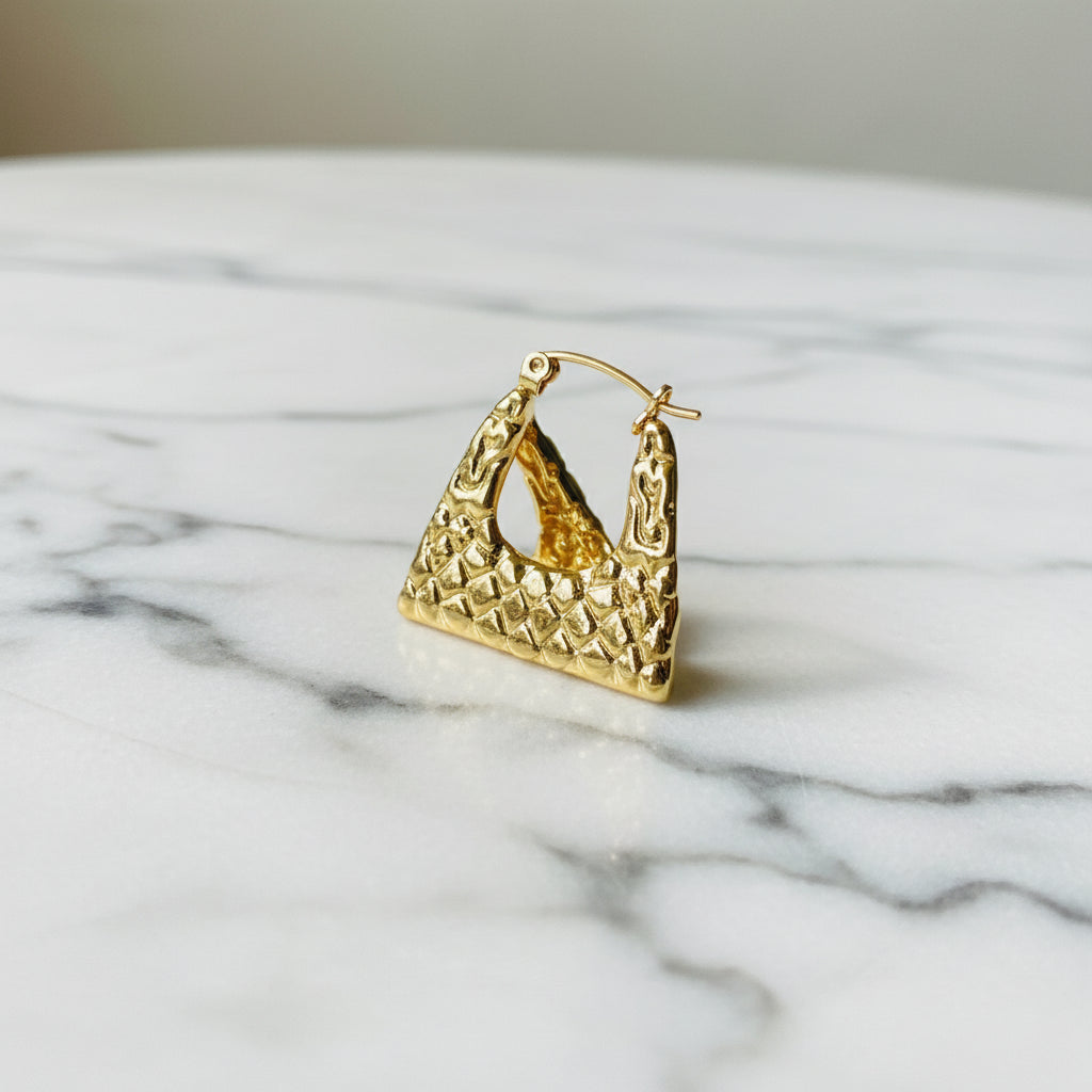 Gold crown-shaped object on a white stand with a blurred outdoor background gold crocodile design earrings stainless steel exclusive Deep Shine Jewellers DSJ jewellery jewelry Your Time To Shine queens womens ladies kingdome 