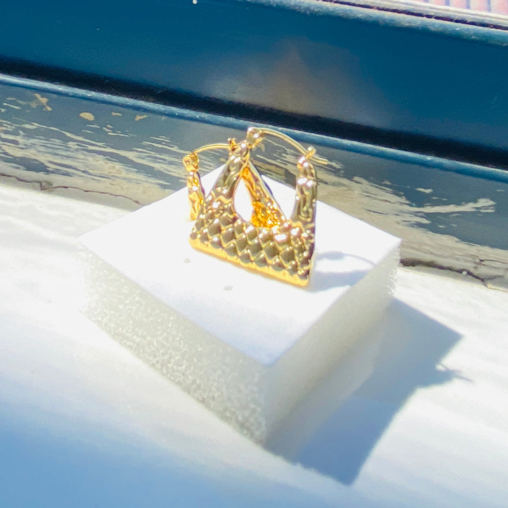 Gold crown-shaped object on a white stand with a blurred outdoor background gold crocodile design earrings stainless steel exclusive Deep Shine Jewellers DSJ jewellery jewelry Your Time To Shine queens womens ladies kingdome 