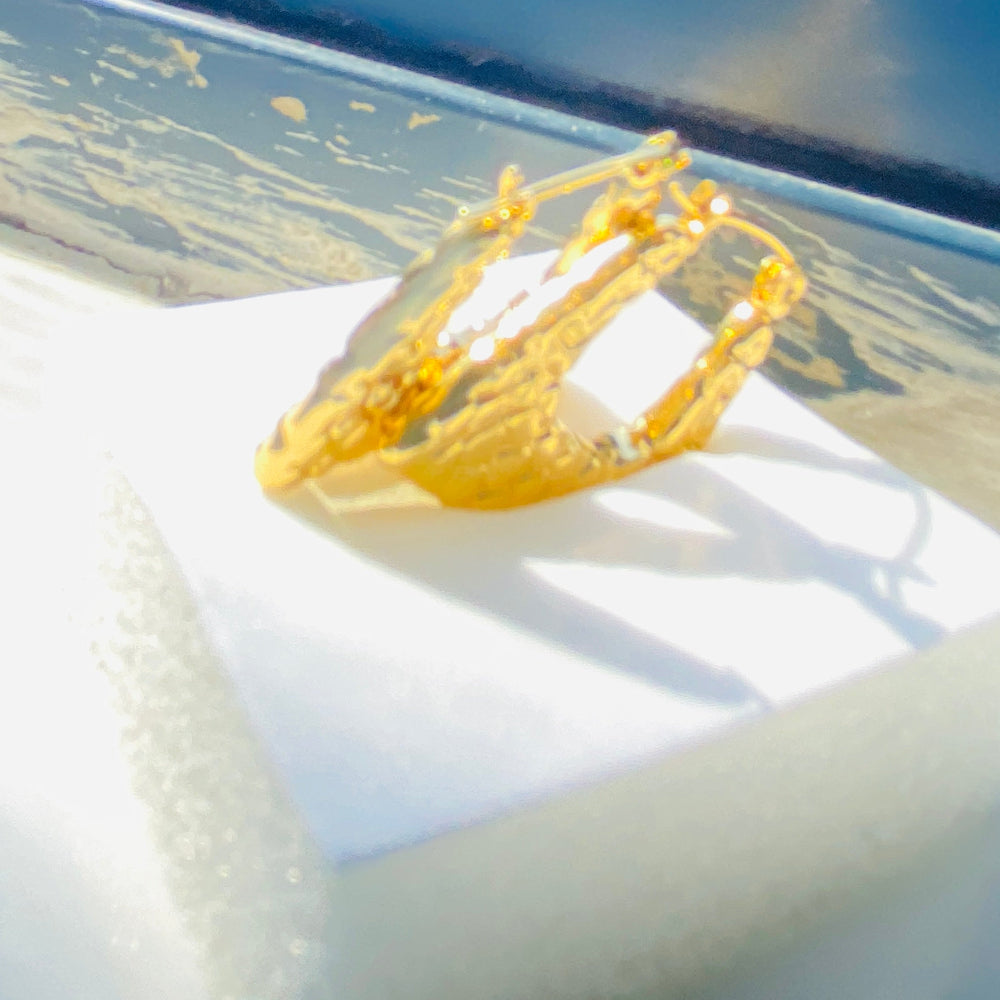 Yellow crown on a white surface with a blurred background Gold crown-shaped object on a white stand with a blurred outdoor background gold crocodile design earrings stainless steel exclusive Deep Shine Jewellers DSJ jewellery jewelry Your Time To Shine queens womens ladies kingdome 