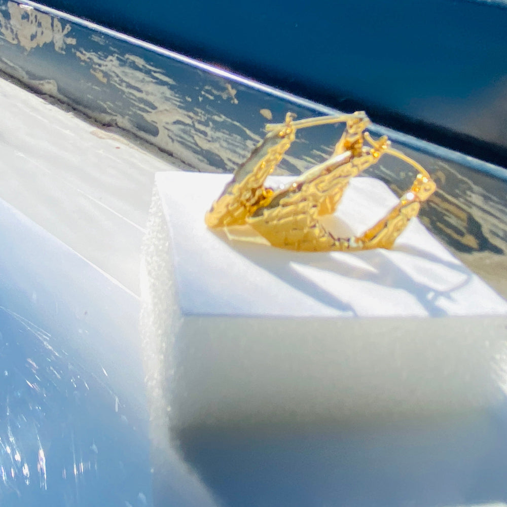 Gold crown on a car's sunshade with a blurred outdoor background. Gold crown-shaped object on a white stand with a blurred outdoor background gold crocodile design earrings stainless steel exclusive Deep Shine Jewellers DSJ jewellery jewelry Your Time To Shine queens womens ladies kingdome 