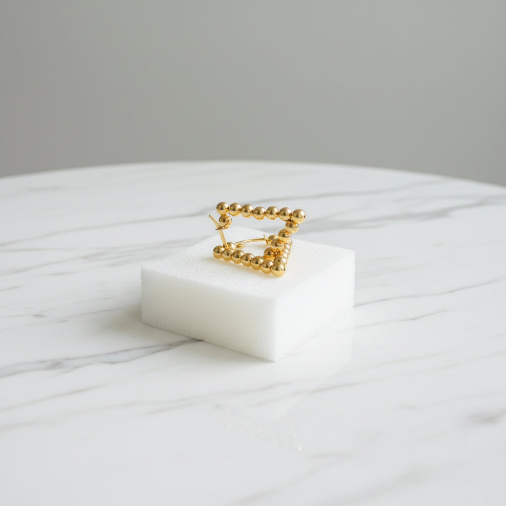 Gold ring on a white cushion with a blurred outdoor background Gold beaded earrings on a blue surface stainless steel gold exclusive earrings Deep Shine Jewellers DSJ jewellery jewelry queens ladies womens kingdom Your Time To Shine