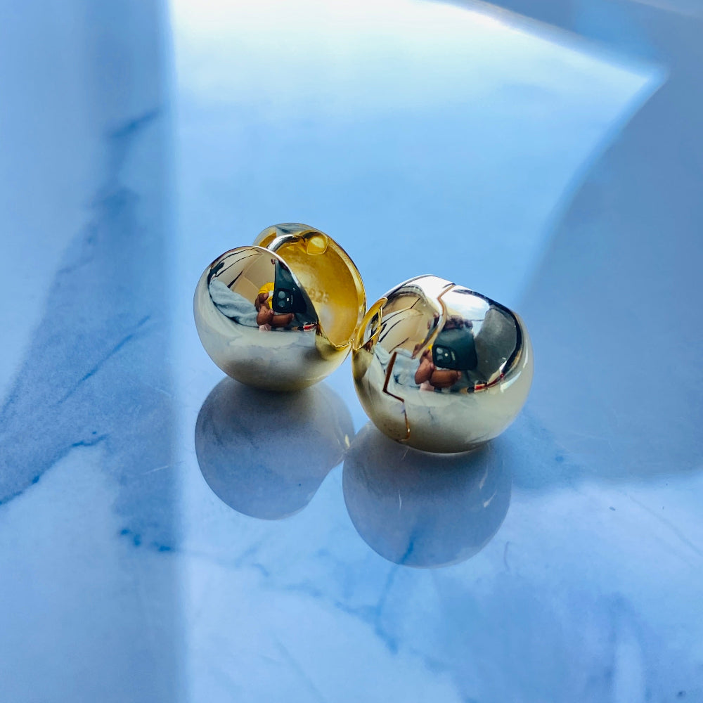 Gold spherical earrings on a reflective surface gold dome silver earrings for queens ladies women 925 silver sterling silver exclusive craftsmanship Deep Shine Jewellers DSJ Your Time To Shine golden affordable luxury jewellery jewelry 