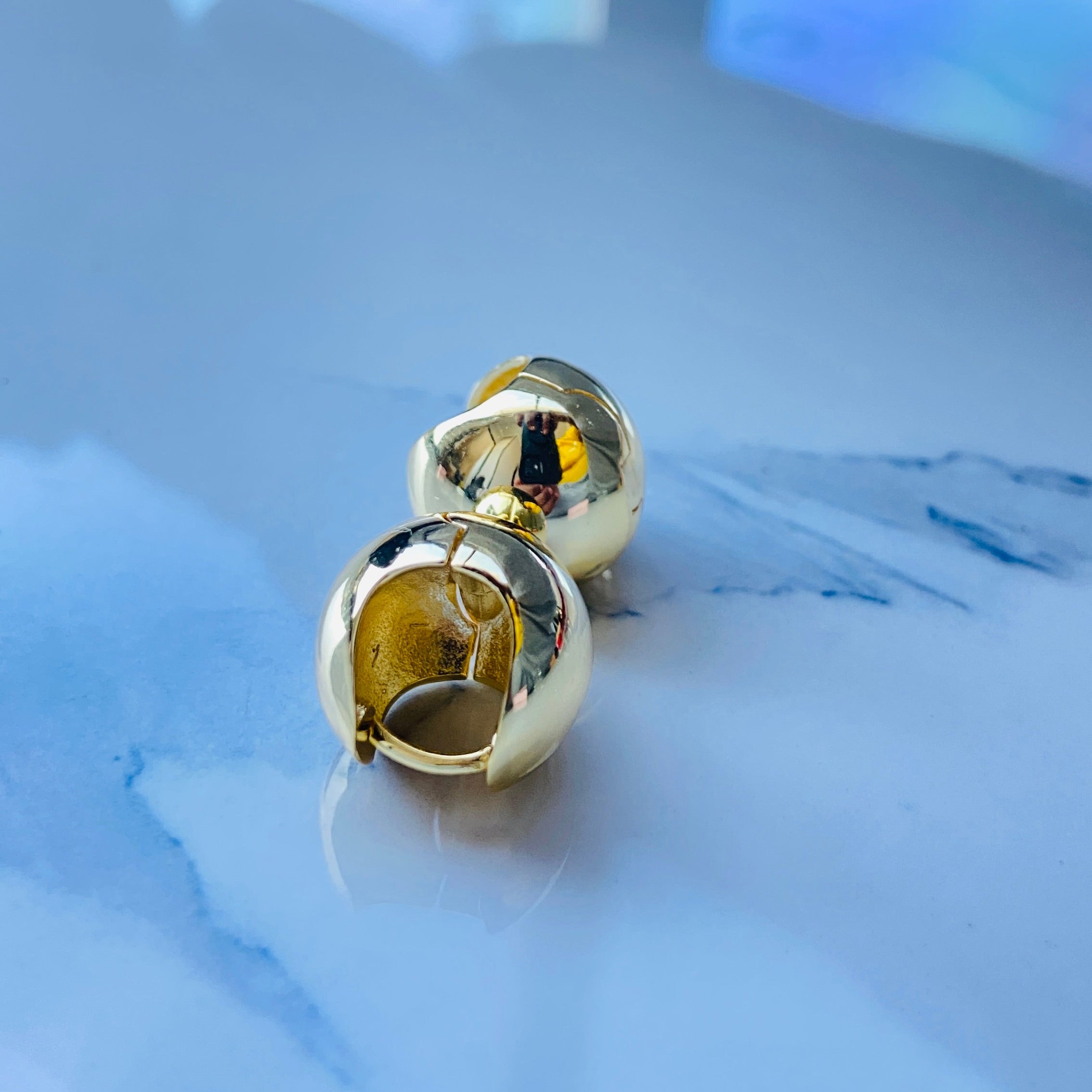 Gold spherical earrings on a reflective surface gold dome silver earrings for queens ladies women 925 silver sterling silver exclusive craftsmanship Deep Shine Jewellers DSJ Your Time To Shine golden affordable luxury jewellery jewelry 