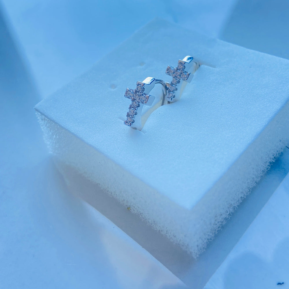 Silver cross-shaped earring on a white stand with a blue background white gold/silver crossed ice earrings cubic zirconia diamonds sleeper hoop Deep Shine Jewellers Jewellers jewelry DSJ. exclusive affordable jewellery Your Time To Shine 925 silver sterling silver 