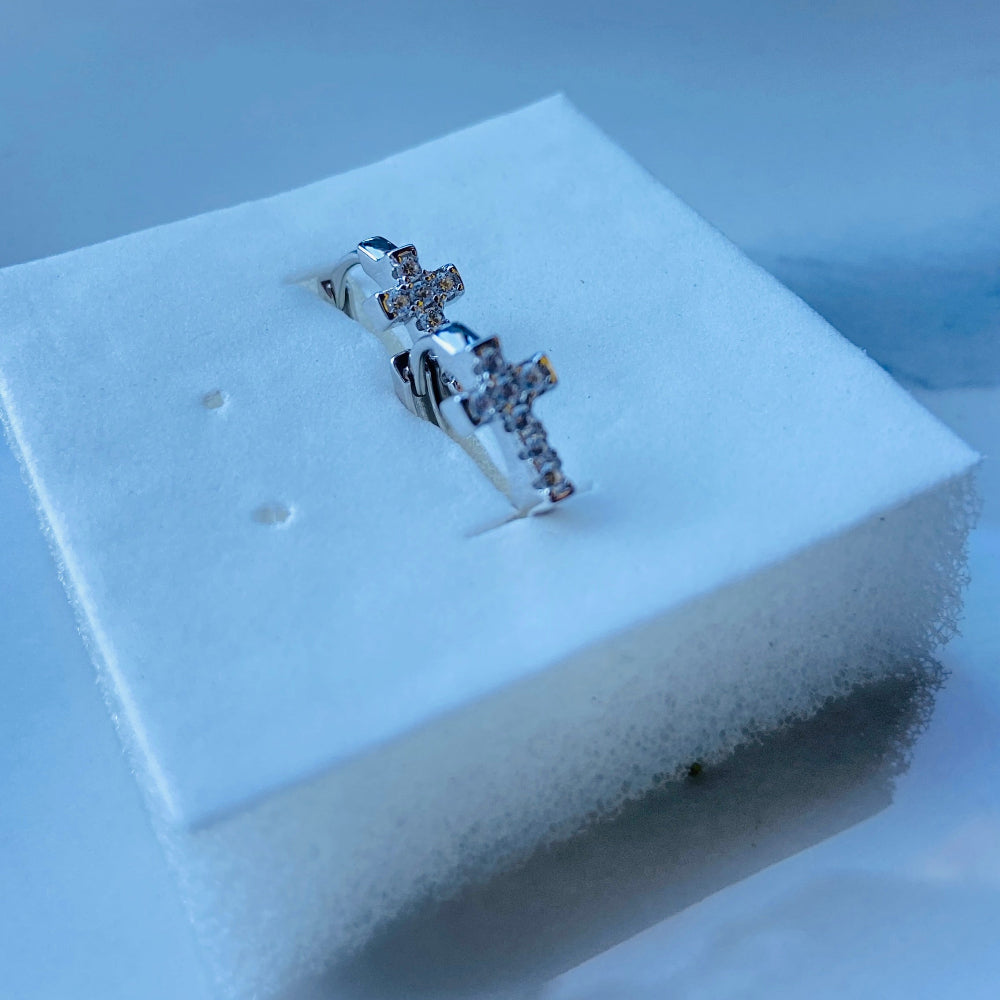 Silver ring on a white foam block with a blurred background white gold/silver crossed ice earrings cubic zirconia diamonds sleeper hoop Deep Shine Jewellers Jewellers jewelry DSJ. exclusive affordable jewellery Your Time To Shine 925 silver sterling silver 