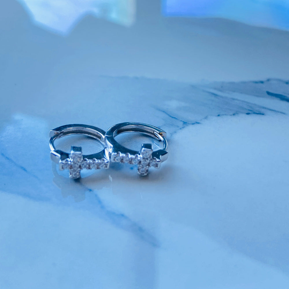 Pair of silver rings with small diamonds on a light blue surface white gold/silver crossed ice earrings cubic zirconia diamonds sleeper hoop Deep Shine Jewellers Jewellers jewelry DSJ. exclusive affordable jewellery Your Time To Shine 925 silver sterling silver 