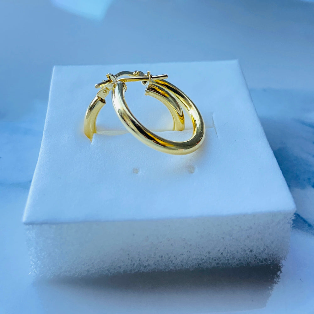 Gold hoop earring on a white jewelry display box with a blue background Gold silver sleepers for mens women kings queens man lady kingdom exclusive by Deep Shine Jewellers jewellery jewelry affordable luxury shinning DSJ Your Time To Shine Cape town craftsmanship 