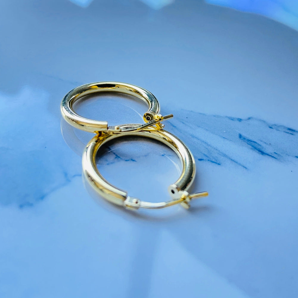 Gold hoop earrings on a blue fabric background Gold silver sleepers for mens women kings queens man lady kingdom exclusive by Deep Shine Jewellers jewellery jewelry affordable luxury shinning DSJ Your Time To Shine Cape town craftsmanship 