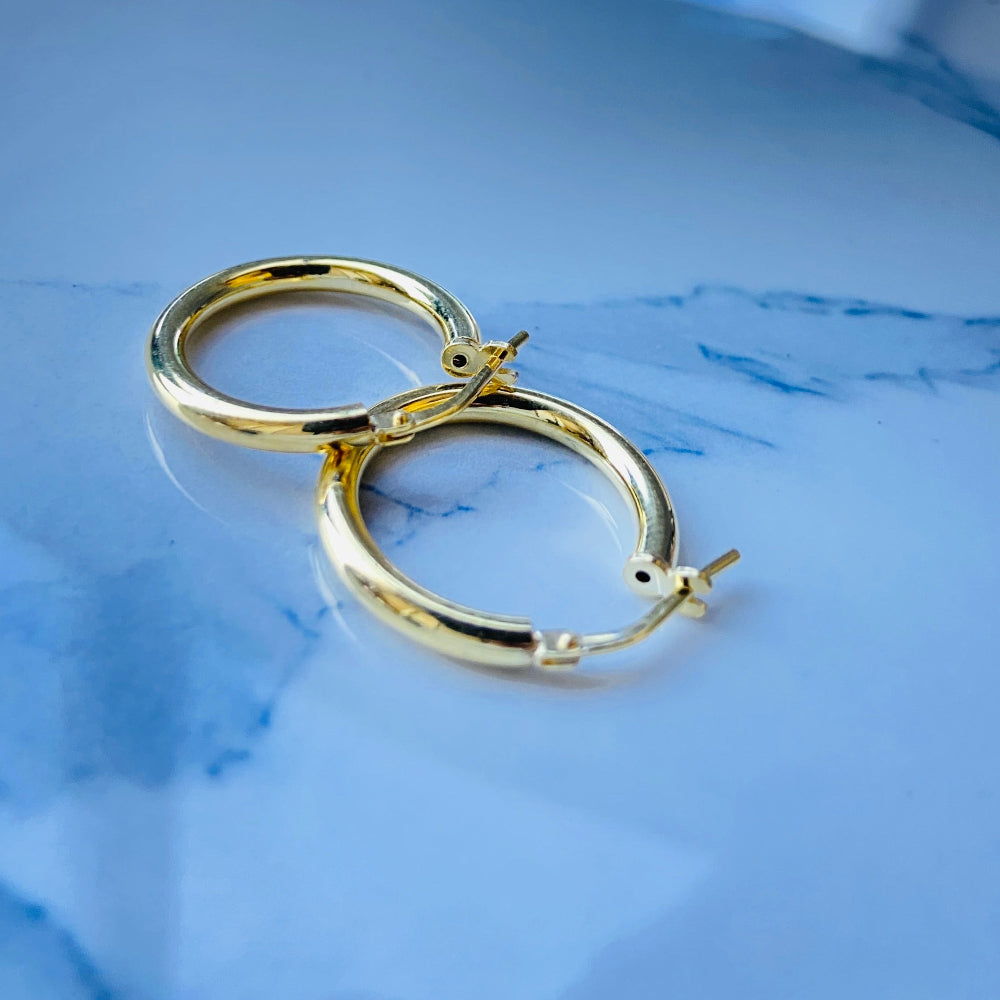 Gold hoop earrings on a blue fabric background Gold silver sleepers for mens women kings queens man lady kingdom exclusive by Deep Shine Jewellers jewellery jewelry affordable luxury shinning DSJ Your Time To Shine Cape town craftsmanship 