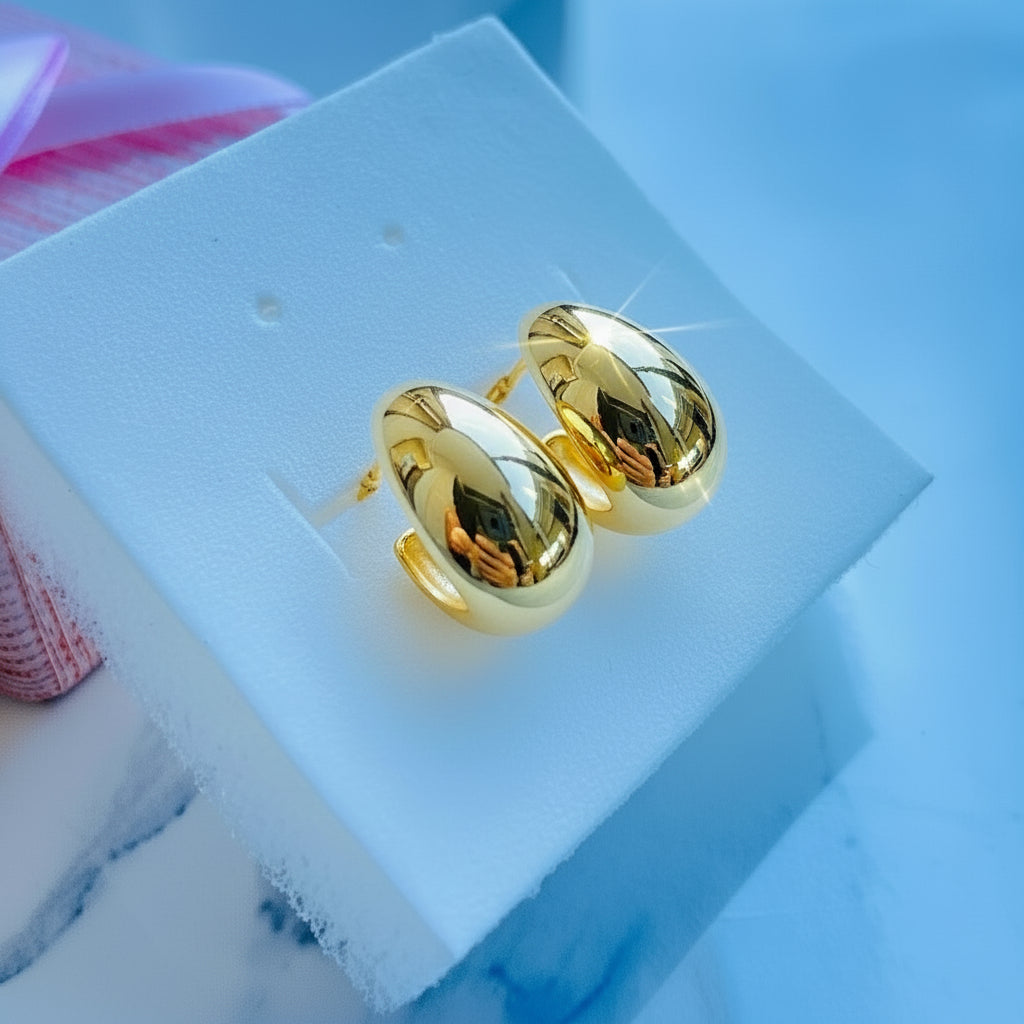 Gold earrings on a white stand with a blue background gold silver rain drop earrings for women ladies queens 925 silver sterling silver exclusive jewellery crafted jewelry kingdom of DSJ Deep Shine Jewellers Your Time To Shine gold plated shinning 