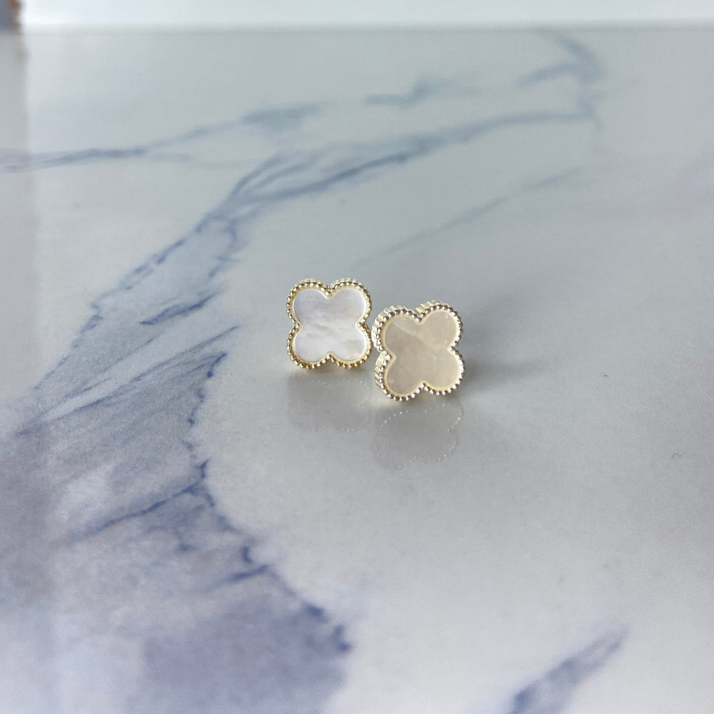 Gold flower-shaped earrings on a marble surface silver mother of pearl clover earrings van cleef & arpels 925 silver sterling silver marble floors exclusive craftsmanship affordable luxury premium jewellery jewelry Deep Shine Jewellers Your Time To Shine DSJ best sellers trending online store christmas sale 