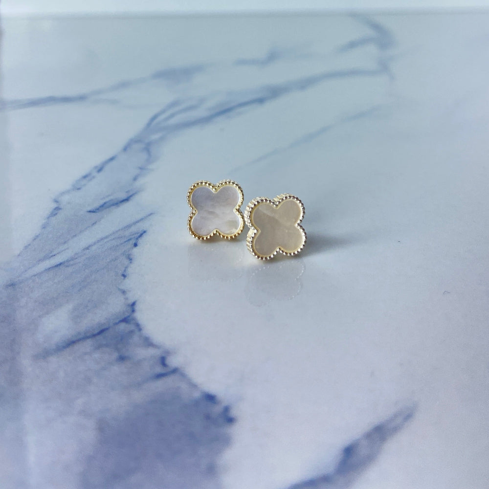 Gold clover-shaped earrings on a marble background Gold flower-shaped earrings on a marble surface silver mother of pearl clover earrings van cleef & arpels 925 silver sterling silver marble floors exclusive craftsmanship affordable luxury premium jewellery jewelry Deep Shine Jewellers Your Time To Shine DSJ best sellers trending online store christmas sale 