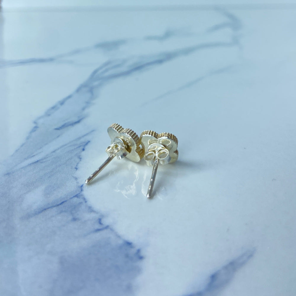 Gold stud earrings on a marble surface Gold flower-shaped earrings on a marble surface silver mother of pearl clover earrings van cleef & arpels 925 silver sterling silver marble floors exclusive craftsmanship affordable luxury premium jewellery jewelry Deep Shine Jewellers Your Time To Shine DSJ best sellers trending online store christmas sale 