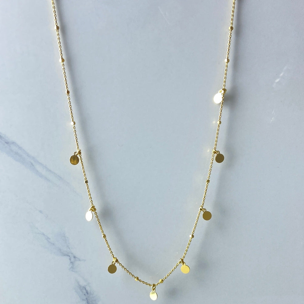 Gold necklace with small round pendants on a marble surface Gold necklace with round pendants on a blue marble surface Radiant Gold Circle and Block Link Necklace by Deep Shine Jewellers gold plated golden 925 silver sterling silver women ladies queens elegant exclusive craftsmanship cape town artisans affordable luxury premium jewellery jewelry chains best sellers trending online store shop now Your Time To Shine DSJ 