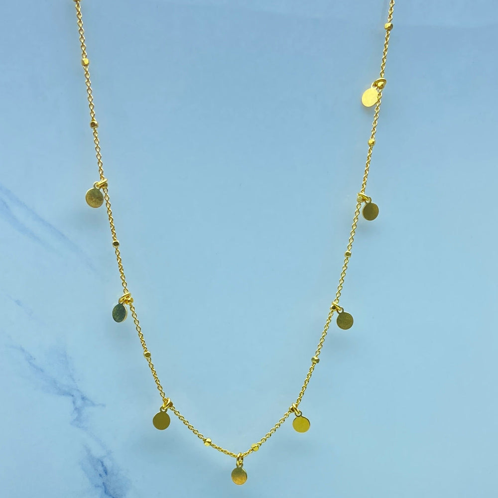 Gold necklace on a light blue marble surface Gold necklace with round pendants on a blue marble surface Radiant Gold Circle and Block Link Necklace by Deep Shine Jewellers gold plated golden 925 silver sterling silver women ladies queens elegant exclusive craftsmanship cape town artisans affordable luxury premium jewellery jewelry chains best sellers trending online store shop now Your Time To Shine DSJ 