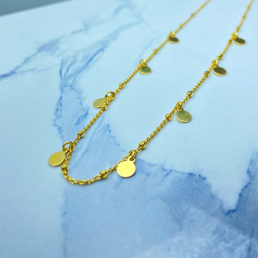 Gold necklace with round pendants on a blue marble surface Radiant Gold Circle and Block Link Necklace by Deep Shine Jewellers gold plated golden 925 silver sterling silver women ladies queens elegant exclusive craftsmanship cape town artisans affordable luxury premium jewellery jewelry chains best sellers trending online store shop now Your Time To Shine DSJ 
