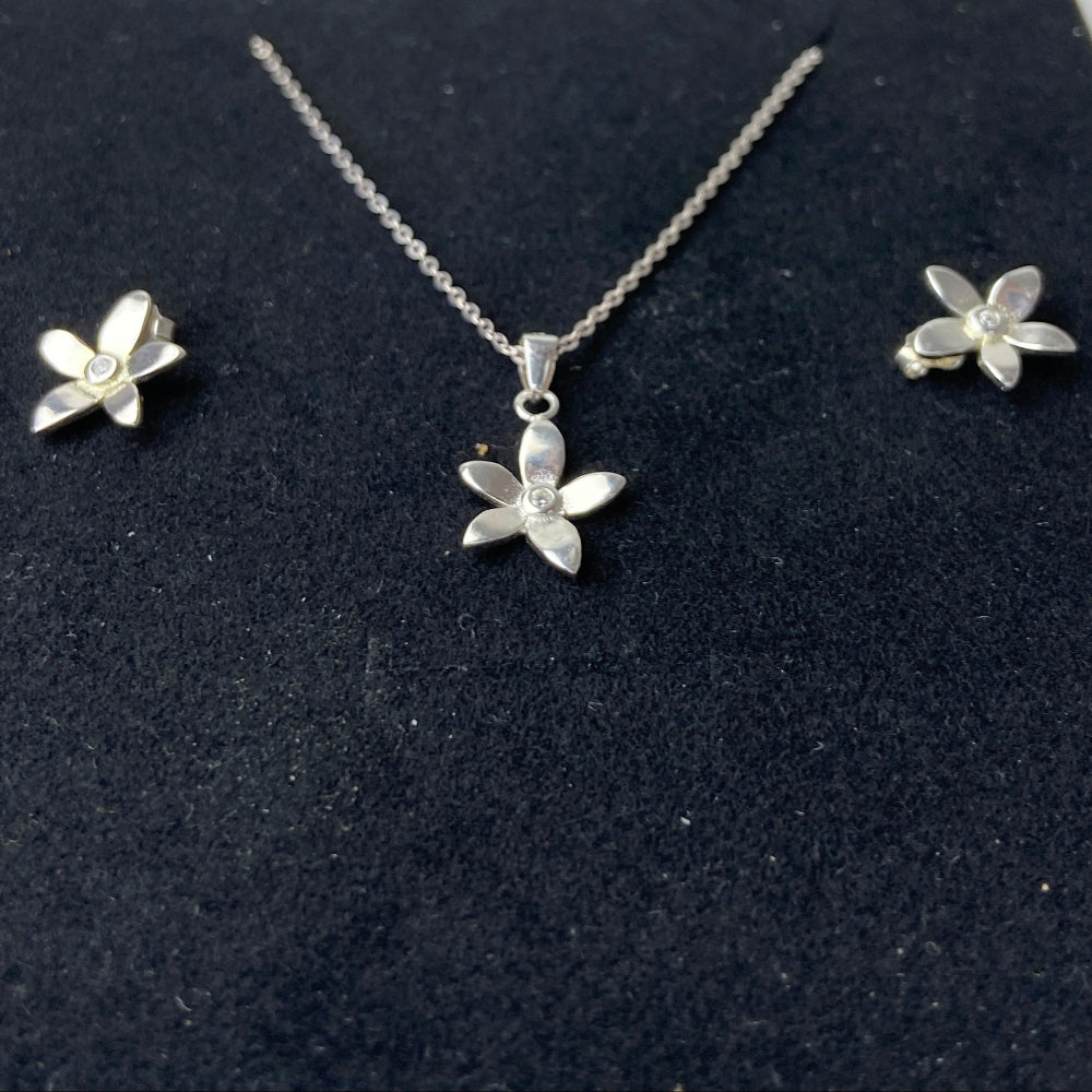 Silver flower necklace and earrings set on a black display card. Silver flower-shaped earrings on a marble surface with a blurred background silver flower stud earrings diamond lab diamond cubic zirconia gemstone women ladies queens exclusive craftsmanship cape town affordable luxury premium jewellery jewelry Deep Shine Jewellers DSJ Your Time To Shine best sellers trending 925 silver sterling silver shop now christmas sale 