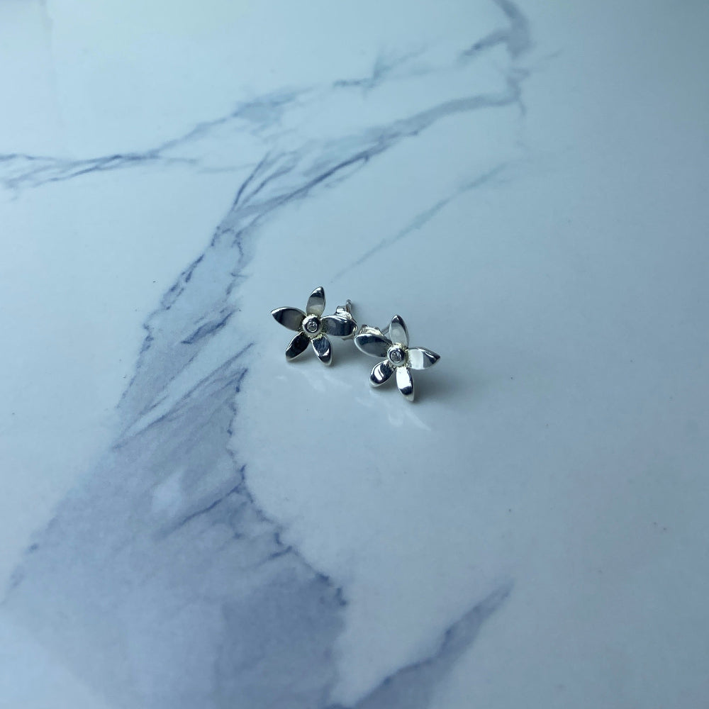 Silver flower-shaped earrings on a marble surface Silver flower-shaped earrings on a marble surface with a blurred background silver flower stud earrings diamond lab diamond cubic zirconia gemstone women ladies queens exclusive craftsmanship cape town affordable luxury premium jewellery jewelry Deep Shine Jewellers DSJ Your Time To Shine best sellers trending 925 silver sterling silver shop now christmas sale 