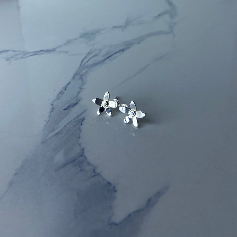 Silver flower-shaped earrings on a marble surface Silver flower-shaped earrings on a marble surface with a blurred background silver flower stud earrings diamond lab diamond cubic zirconia gemstone women ladies queens exclusive craftsmanship cape town affordable luxury premium jewellery jewelry Deep Shine Jewellers DSJ Your Time To Shine best sellers trending 925 silver sterling silver shop now christmas sale 