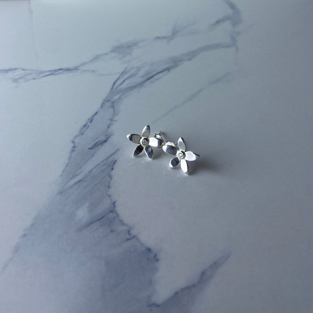 Silver floral earring on a marble surface Silver flower-shaped earrings on a marble surface with a blurred background silver flower stud earrings diamond lab diamond cubic zirconia gemstone women ladies queens exclusive craftsmanship cape town affordable luxury premium jewellery jewelry Deep Shine Jewellers DSJ Your Time To Shine best sellers trending 925 silver sterling silver shop now christmas sale 