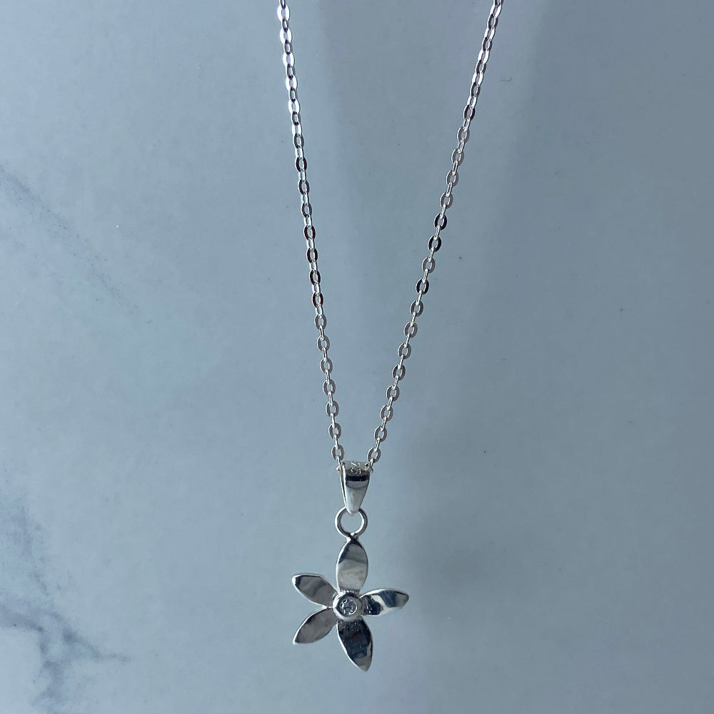 Silver flower-shaped earrings on a marble surface with a blurred background silver flower stud earrings diamond lab diamond cubic zirconia gemstone women ladies queens exclusive craftsmanship cape town affordable luxury premium jewellery jewelry Deep Shine Jewellers DSJ Your Time To Shine best sellers trending 925 silver sterling silver shop now christmas sale 