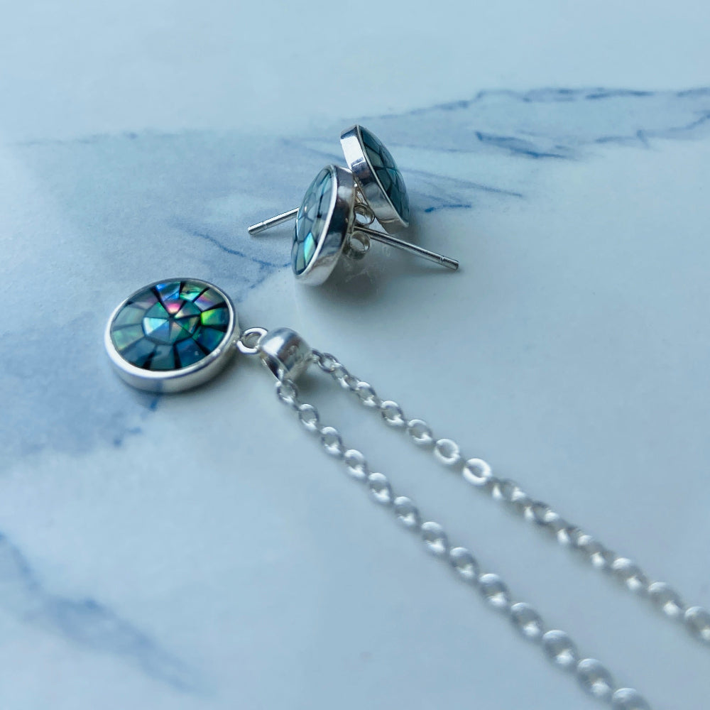 Silver necklace with a round pendant on a marble surface Two necklaces with round pendants on a marble surface silver paua necklace and earrings set chain women ladies queens 925 silver sterling silver exclusive craftsmanship elegance affordable luxury premium jewellery jewelry cape town artisans high quality best sellers trending Deep Shine Jewellers DSJ Your Time To Shine shop now kingdom Christmas sale 