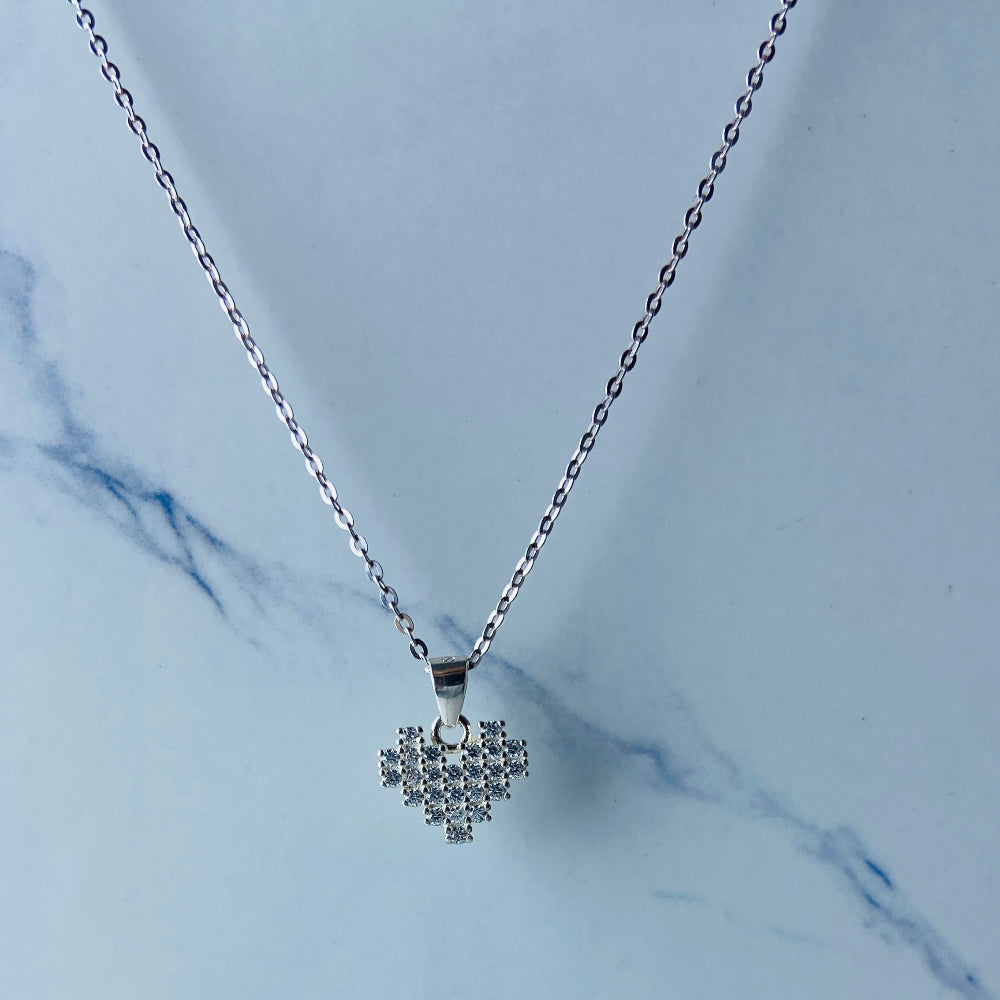 Necklace with a heart-shaped diamond pendant on a marble background Silver butterfly-shaped earrings on a marble surface Radiant Silver Pixelated Heart Necklace and Earrings Set by Deep Shine Jewellery women ladies queens 925 silver sterling silver cubic zirconia gemstone diamond lab diamond exclusive craftsmanship cape town artisans affordable luxury best seller trending christmas sale gift wishlish Your Time To Shine DSJ online store shop now 