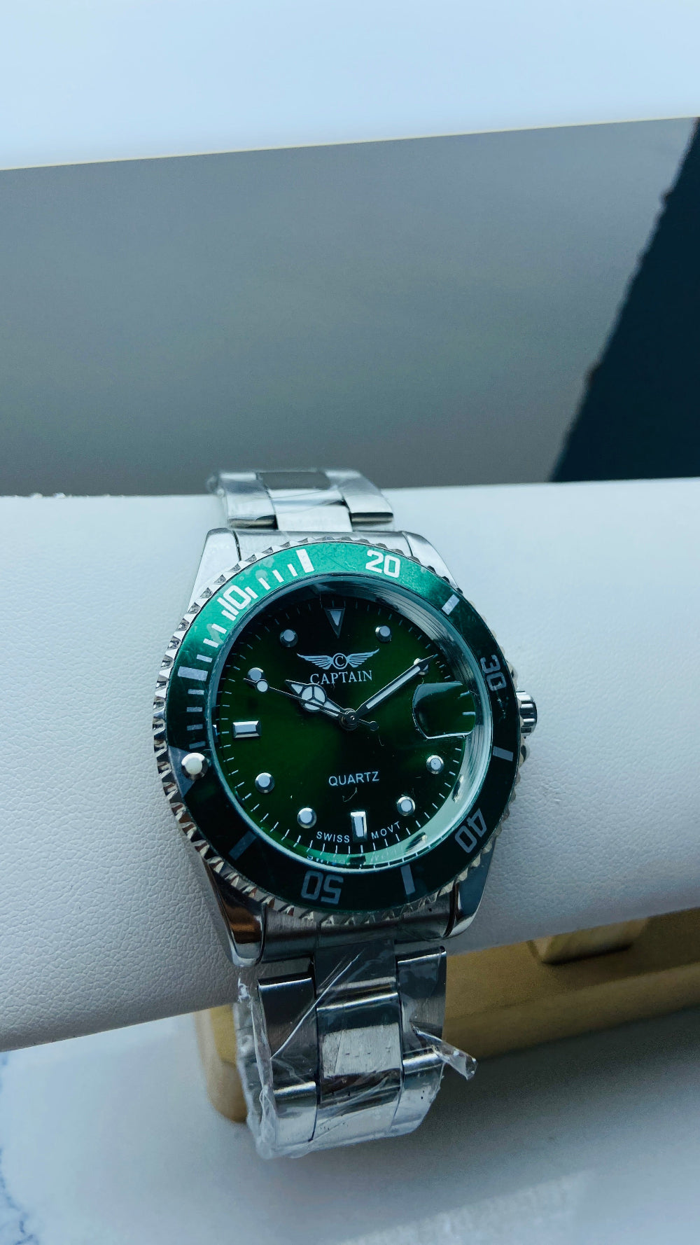 Green wristwatch with silver band on a white surface Silver watch with black dial on a white surface captain mens watch black dial stainless steel rotating bezel quartz movement swiss movement timepiece watches timeless elegance brand new polished watched sapphire crystal hour markings jewellery jewelry premium quality affordable luxury best sellers trending shop now Deep Shine Jewellers DSJ Your Time To Shine mens gents kings 