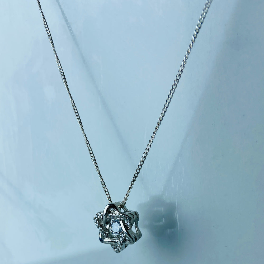 Silver necklace with a star-shaped pendant on a light blue marble background Silver necklace with a floral pendant on a marble surface white gold silver dancing diamond pendant necklace chain diamond cubic zirconia gemstone lab diamond exclusive craftsmanship affordable luxury premium jewellery jewelry ladies women queens Deep Shine Jewellers DSJ Your Time To Shine best seller trending 925 silver sterling silver 