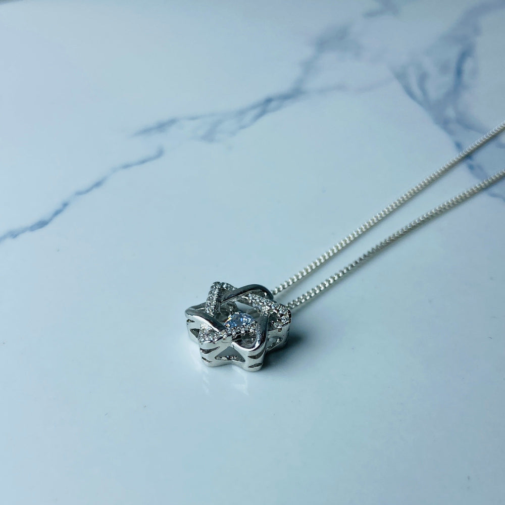 Silver necklace with a floral pendant on a marble surface white gold silver dancing diamond pendant necklace chain diamond cubic zirconia gemstone lab diamond exclusive craftsmanship affordable luxury premium jewellery jewelry ladies women queens Deep Shine Jewellers DSJ Your Time To Shine best seller trending 925 silver sterling silver 