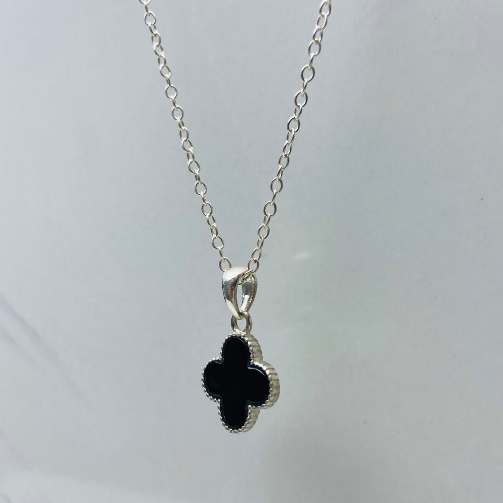 Silver necklace with a black clover pendant on a white background Necklace with a black clover pendant on a marble surface Silver necklace with a floral pendant on a marble surface white gold silver onyx clover pendant necklace chain exclusive craftsmanship affordable luxury premium jewellery jewelry ladies women queens Deep Shine Jewellers DSJ Your Time To Shine best seller trending 925 silver sterling silver Van Cleef and Arpels lucky clover gemstone VC&A Christmas sale gifts festive season holidays xmas