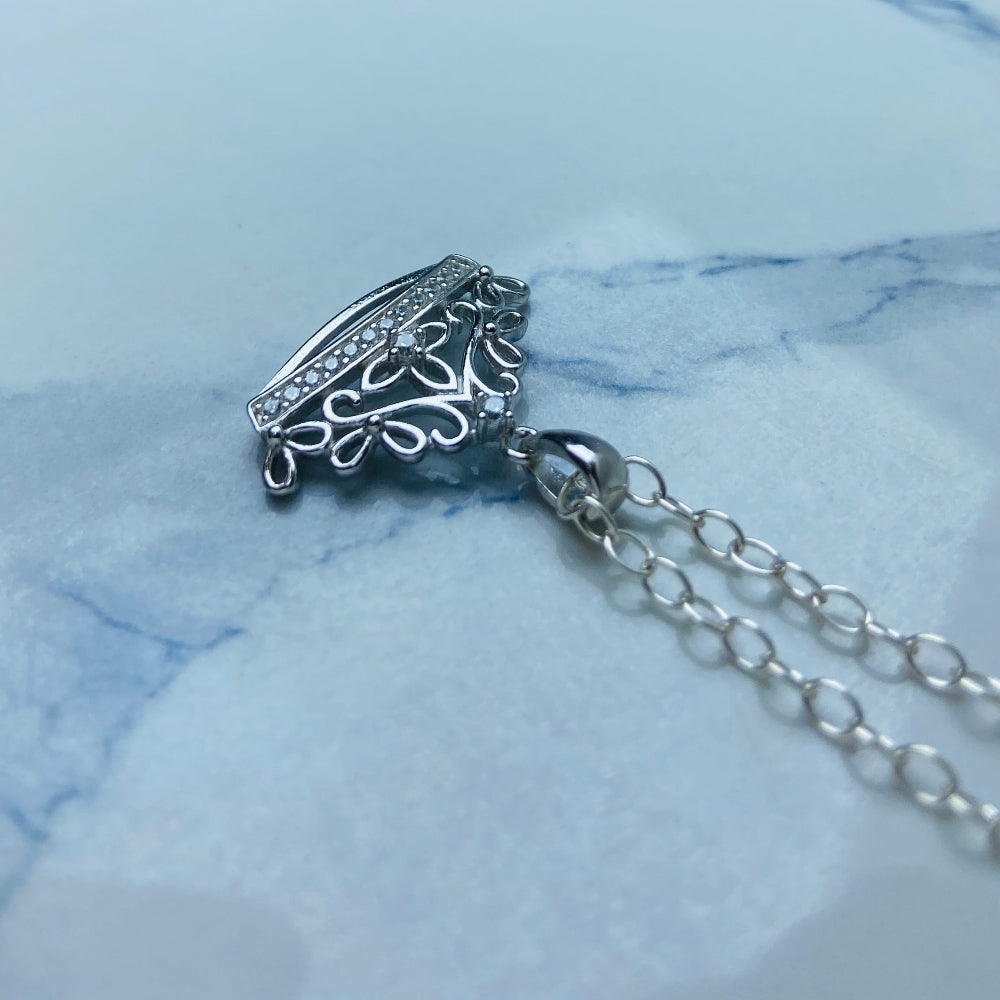 Silver necklace with a detailed pendant on a marble surface Silver necklace with a detailed pendant on a marble background Silver necklace silver crown pendant necklace chain exclusive craftsmanship affordable luxury premium jewellery jewelry ladies women queens Deep Shine Jewellers DSJ Your Time To Shine best seller trending 925 silver sterling silver diamond lab diamond gemstones cubic zirconia Christmas special sale festive season holidays gift loved ones cable chain