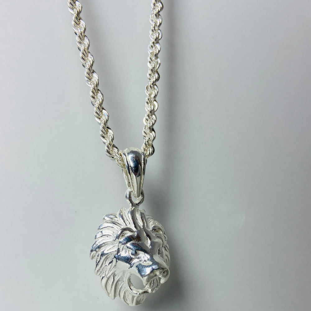 Silver necklace with a clear crystal pendant on a light gray background Silver lion head pendant on a chain against a marble background Silver Lions head pendant necklace marble surface pendant necklace curb chain exclusive craftsmanship affordable luxury premium jewellery jewelry ladies women queens kings mens gents Deep Shine Jewellers DSJ Your Time To Shine best seller trending 925 silver sterling silver cape town artisans christmas gifts present festive season holiday gifts for love ones
